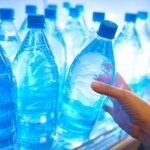 close-up-of-hand-pick-up-water-bottle-from-shelf